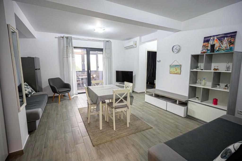 a living room with a table and a dining room at Apartament Azer Eforie Nord in Eforie