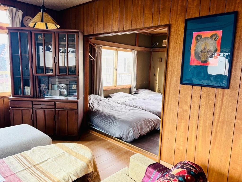 a room with two beds in a room with a mirror at BEAR FOOT apartment in Yakumo