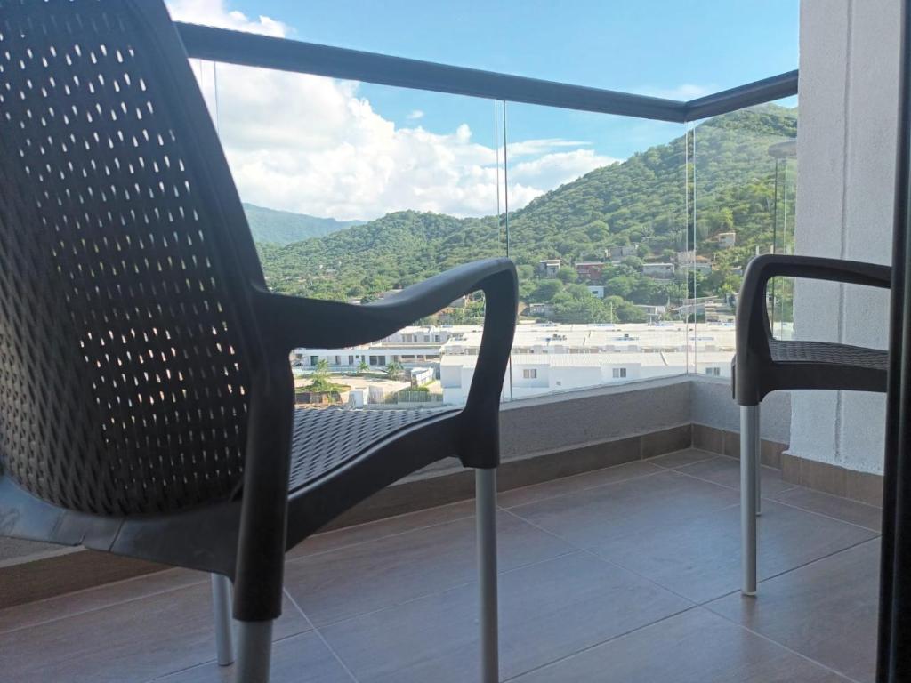 a chair sitting on top of a balcony with a view at La posada de Mayté in Santa Marta
