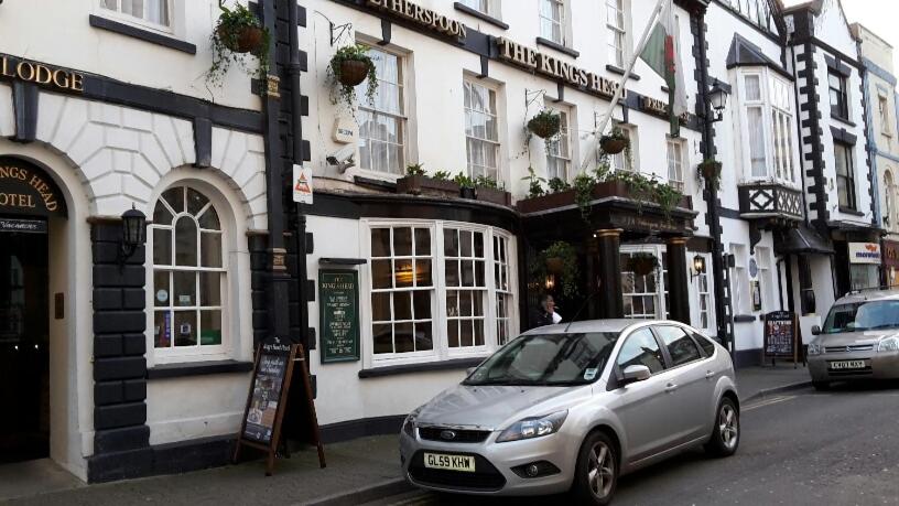 een zilveren auto geparkeerd voor een gebouw bij The King's Head Hotel - JD Wetherspoon in Monmouth