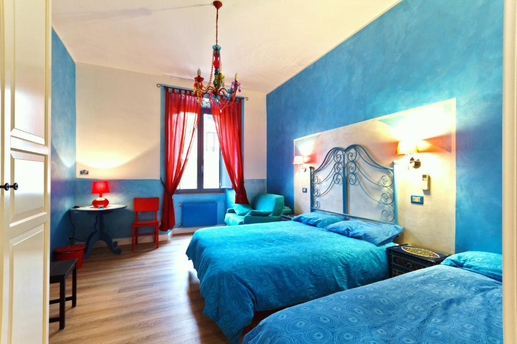 1 dormitorio azul con 2 camas y 1 silla en Dream Station, en Roma