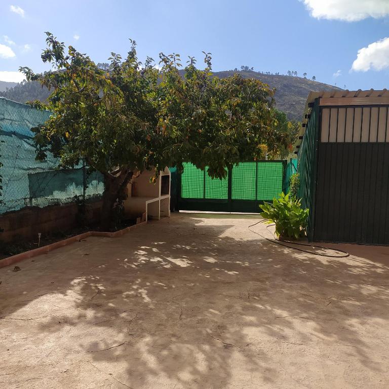 a building with a green fence and a tree at Casa Haza San Luis in Riópar