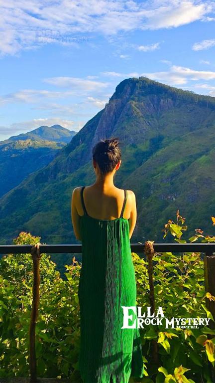 a woman in a green dress looking at the mountains at Ella Rock Mystery Guest in Ella