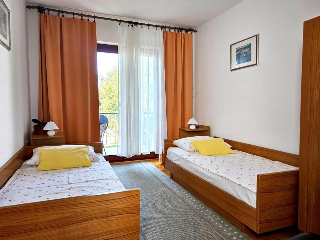sypialnia z dwoma łóżkami i oknem w obiekcie Apartments with a parking space Malinska (Krk) - 2390 w mieście Malinska