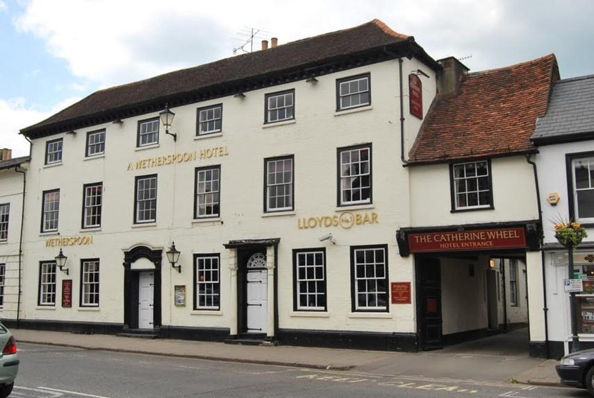 a white building on the corner of a street at The Catherine Wheel Wetherspoon Hotel in Henley on Thames