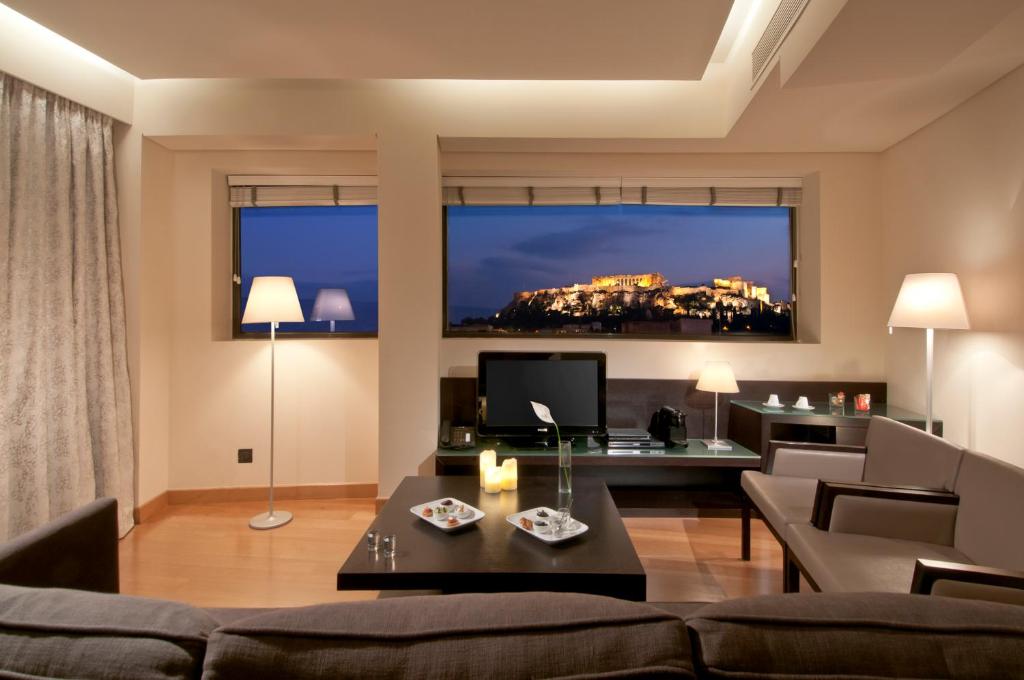 a living room with a couch and a tv at O&B Athens Boutique Hotel in Athens