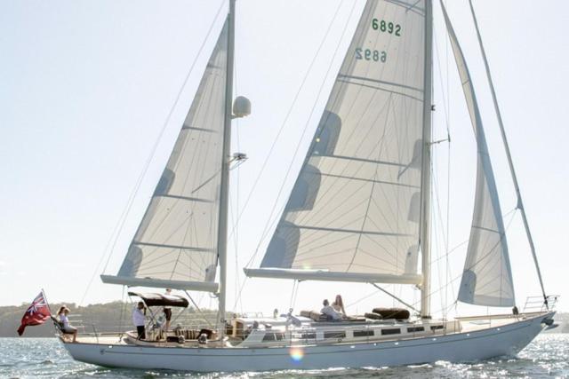 a sail boat in the water with people on it at Sir Thomas Sopwith in Sydney