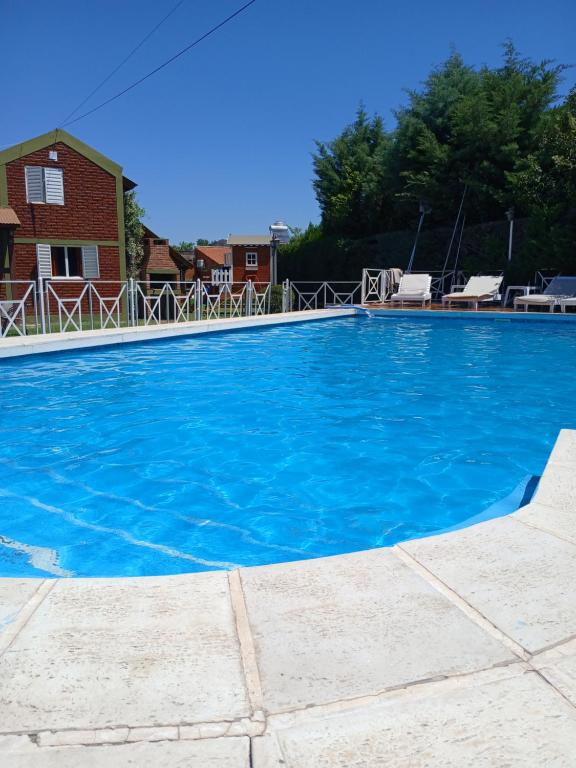 a large blue swimming pool in front of a house at Complejo Cantonavi in Mina Clavero
