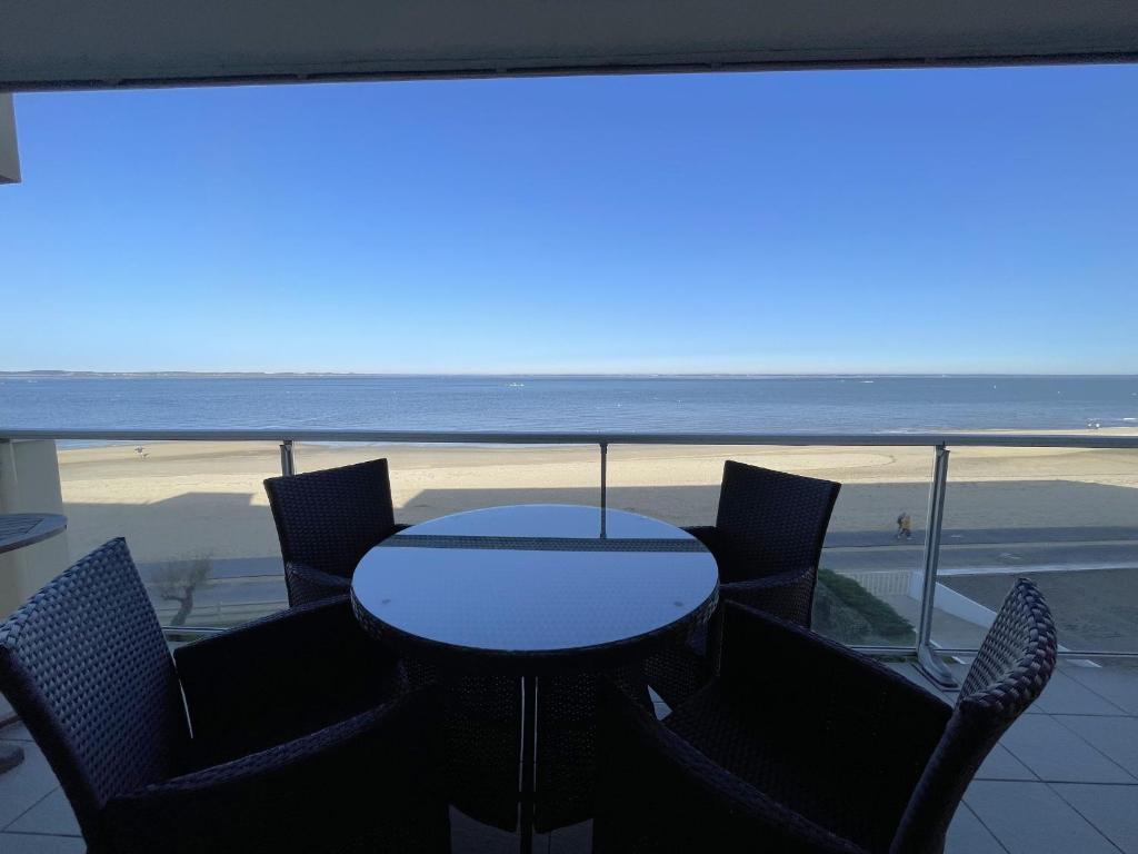 une table et des chaises avec vue sur la plage dans l'établissement Appartement T2 proche centre avec terrasse et parking sous-terrain - FR-1-474-11, à Arcachon