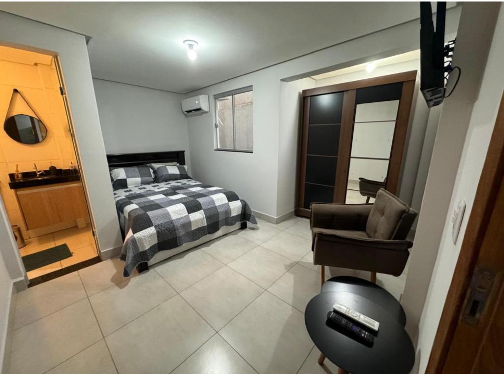 een slaapkamer met een bed en een stoel erin bij Apartamento Setor Universitário in Goiânia