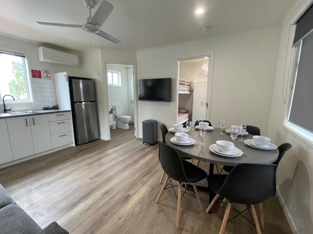 科巴Cobar Caravan Park的配有桌椅的厨房和餐厅