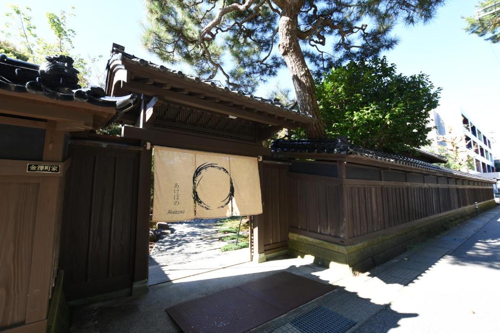 una cerca con un cartel en ella junto a una acera en 金沢之旅宿 あけぼの Kanazawa stay Akebono, en Kanazawa