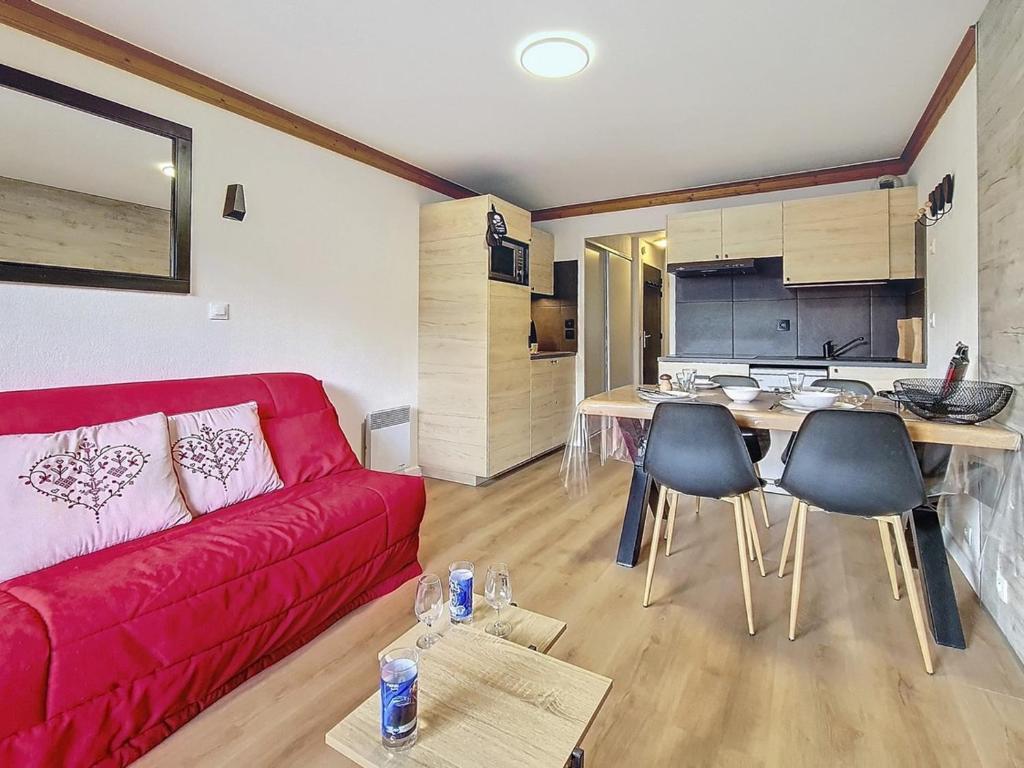 un salon avec un canapé rouge et une cuisine dans l'établissement Appartement rénové 2P, balcon sud-ouest, pied des pistes, parking, wifi, non fumeur. - FR-1-344-1215, aux Bruyères
