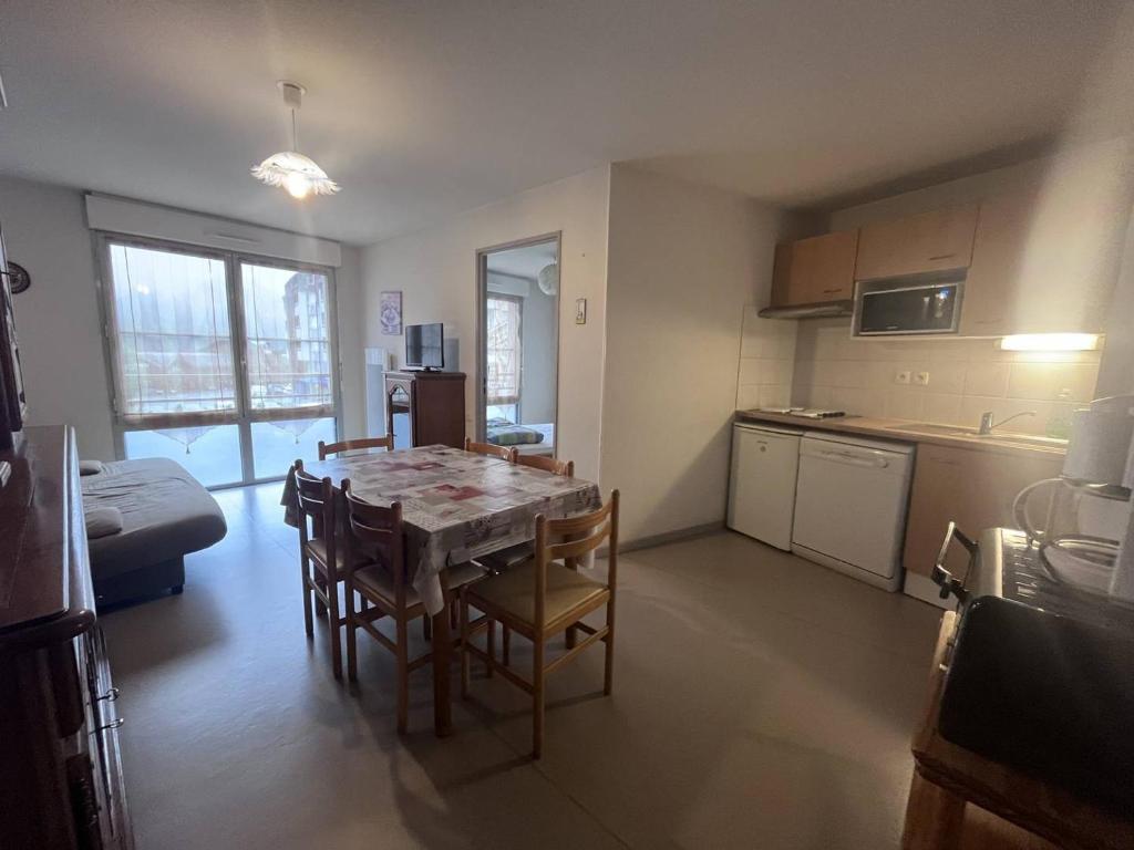 une cuisine et une salle à manger avec une table et des chaises dans l'établissement Charmant appartement à Cauterets avec parking et proche des pistes - FR-1-812-52, à Cauterets