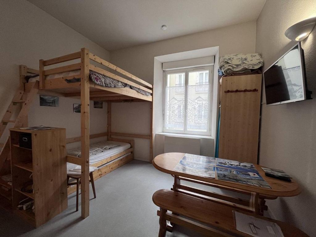Cette petite chambre comprend des lits superposés et une table. dans l'établissement Doux séjour familial à Cauterets - FR-1-812-55, à Cauterets