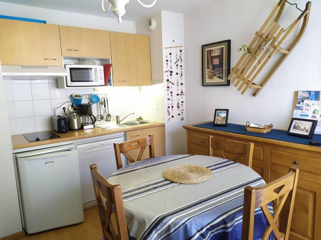 - une petite cuisine avec une table et un comptoir dans l'établissement T2 avec ascenseur, parking privé et cabine lits superposés - FR-1-812-25, à Cauterets