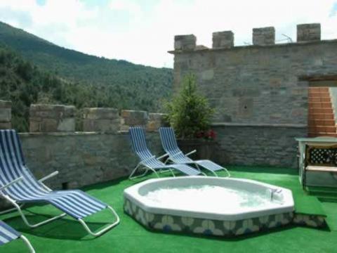 zwei blaue Stühle und eine Badewanne auf einem grünen Rasen in der Unterkunft Las Bodegas De Claveria in El Humo de Muro