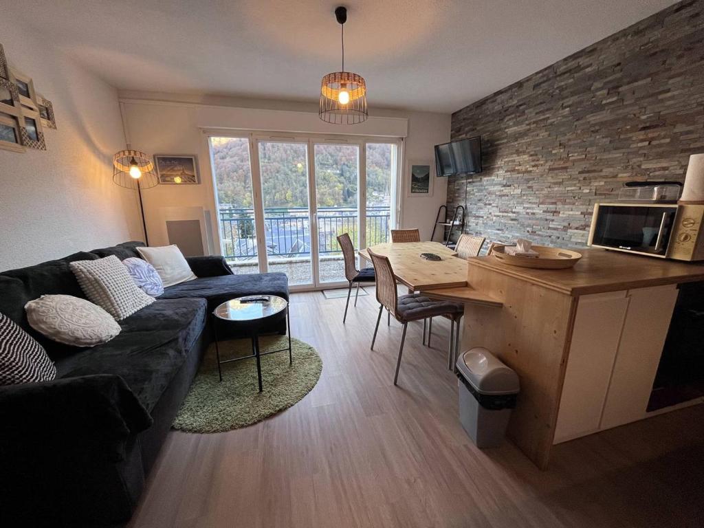 un salon avec un canapé et une table dans l'établissement Appartement avec terrasse et parking, 2 chambres, au cœur des montagnes - FR-1-812-90, à Cauterets