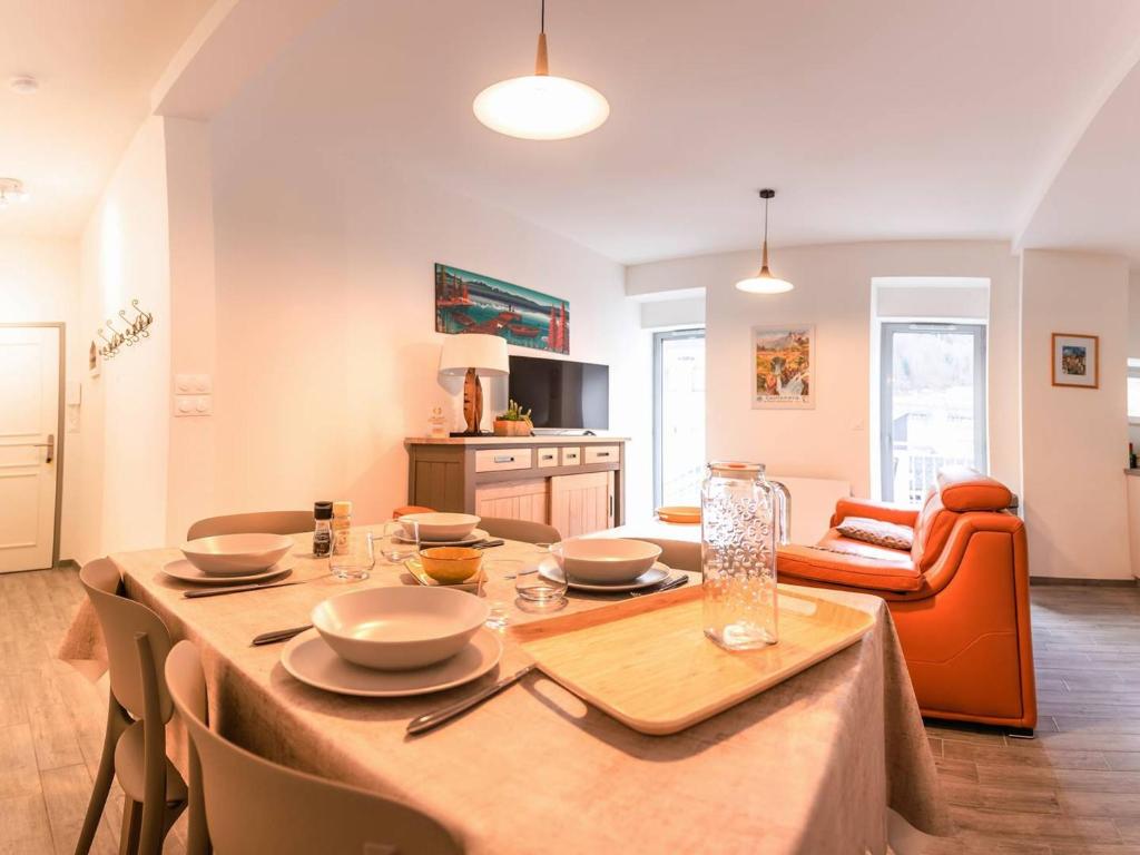 ein Esszimmer mit Tisch und ein Wohnzimmer in der Unterkunft Appartement rénové 4 pers, hyper centre Cauterets - FR-1-812-66 in Cauterets