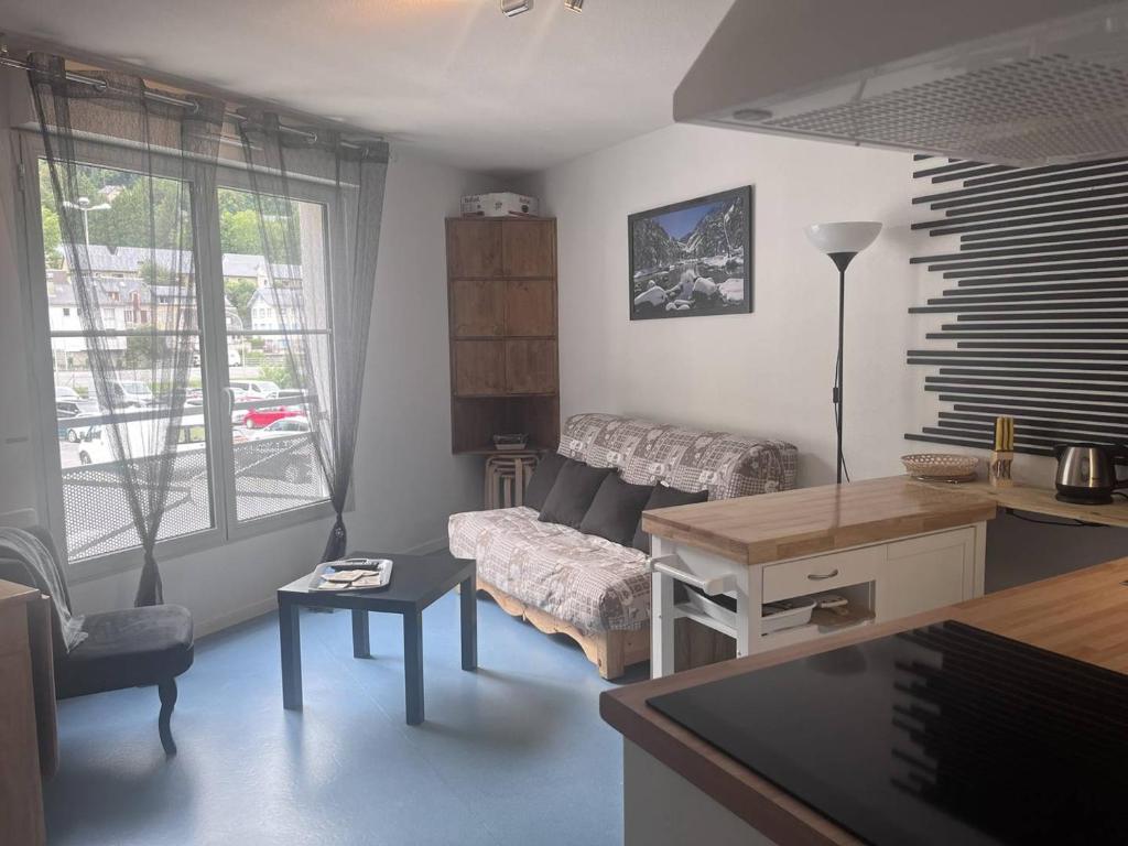 un salon avec un canapé et une table dans l'établissement Appartement cosy avec chambre et alcove, proche des commodités - FR-1-812-80, à Cauterets