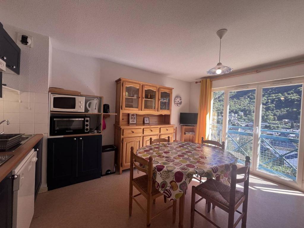 une cuisine avec une table avec des chaises et une salle à manger dans l'établissement Charmant appart 6 pers, 2 ch, à Cauterets avec parking - FR-1-812-104, à Cauterets