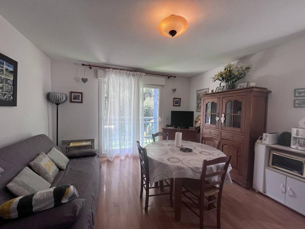 un salon avec une table et un canapé dans l'établissement Charmant appartement avec terrasse et parking privé à Cauterets - FR-1-812-110, à Cauterets