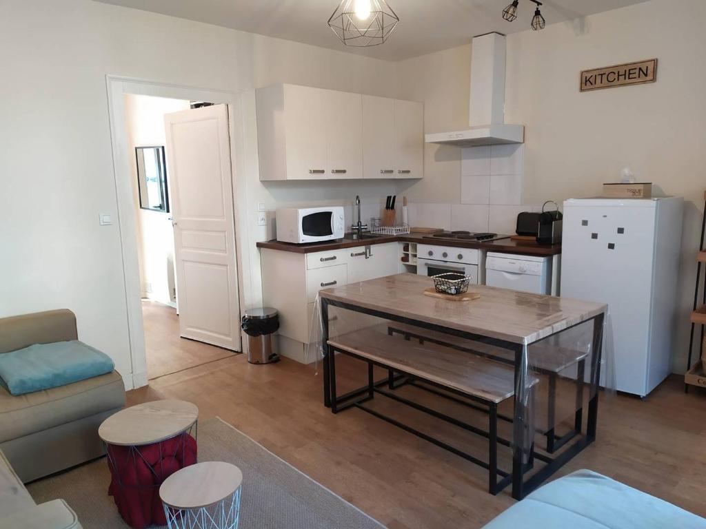 une petite cuisine avec une table et un réfrigérateur dans l'établissement Charmant T2 à Cauterets, proximité nature - FR-1-812-99, à Cauterets