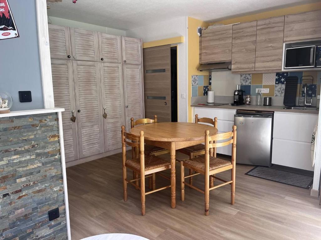 - une cuisine avec une table et des chaises en bois dans la chambre dans l'établissement Charmant chalet 4 pers. à Cauterets avec parking - FR-1-812-113, à Cauterets