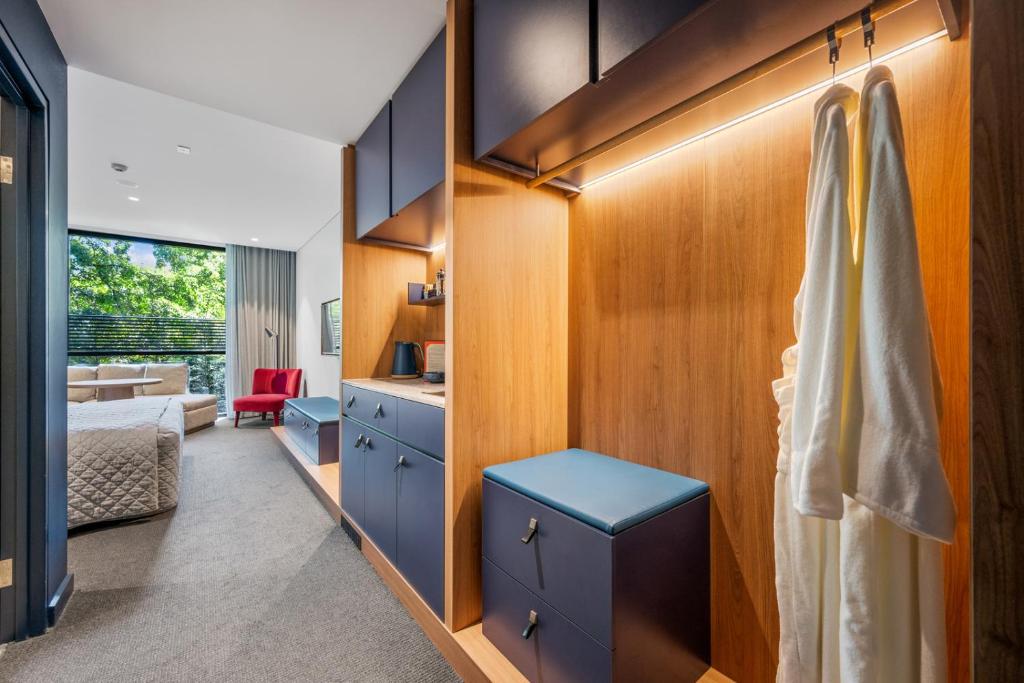 una camera da letto con armadi blu, un letto e una scrivania di Yallungah Boutique Hotel a Orange