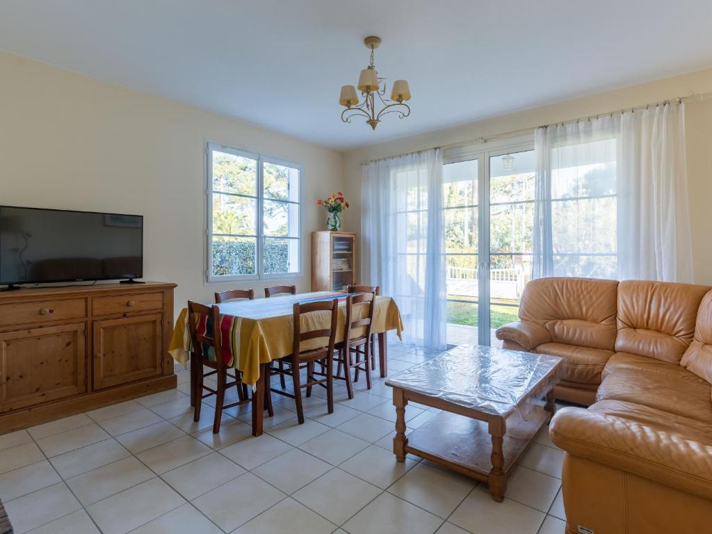 un salon avec une table et un canapé dans l'établissement Maison confortable pour 6 à Mimizan Plage, proche océan et pistes cyclables - FR-1-50-146, à Mimizan