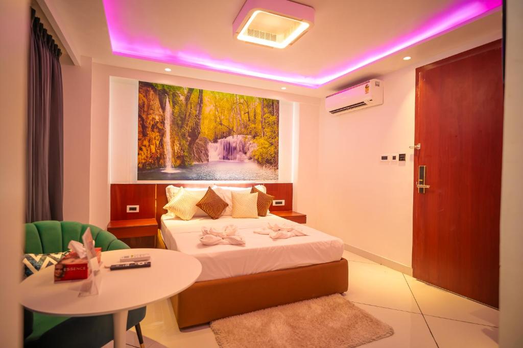 a hotel room with a bed and a table and a painting at J60 Suites, Ashok Vihar - Near Netaji Subhash Place in New Delhi