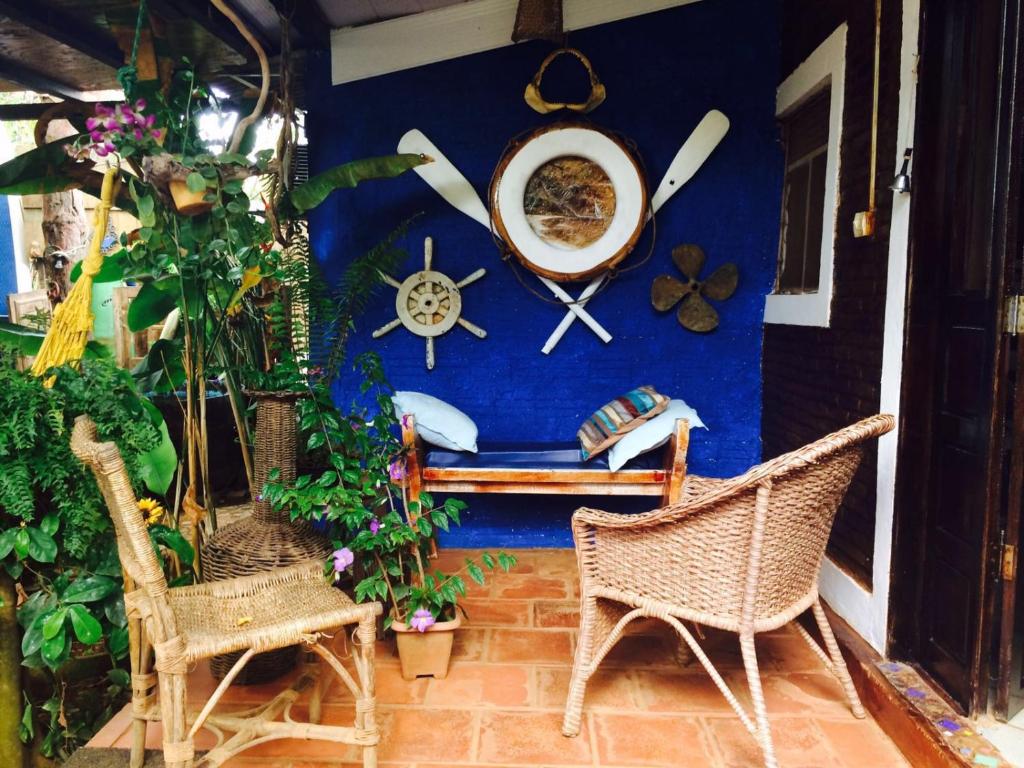 a room with a blue wall with a bench and chairs at Casa de Mirtes in Fernando de Noronha