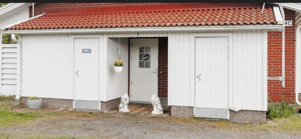 a white garage with a cat sitting in front of it at Paukavuori in Seinäjoki
