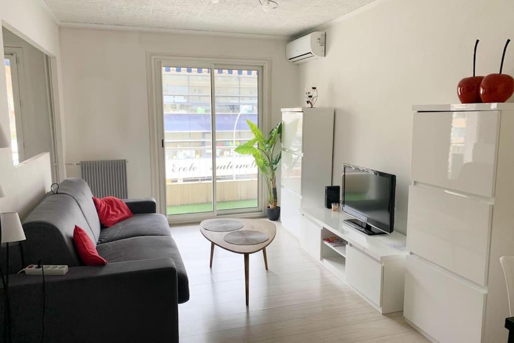 un salon avec un canapé et une télévision dans l'établissement Studio agréable & lumineux proche hôpital Pasteur, à Nice