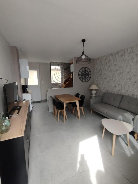 un salon avec un canapé et une table dans l'établissement Maison Montebello, à Sézanne