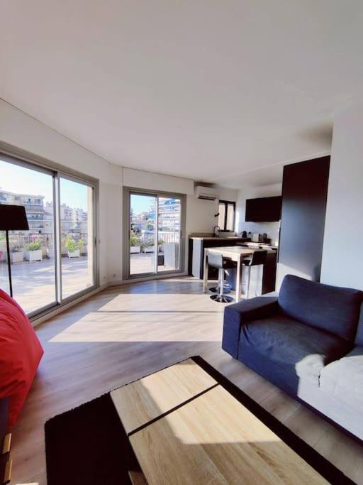 un salon avec un canapé bleu et une cuisine dans l'établissement Romantic 1BR Escape with Sun-Rooftop Terrace, à Nice