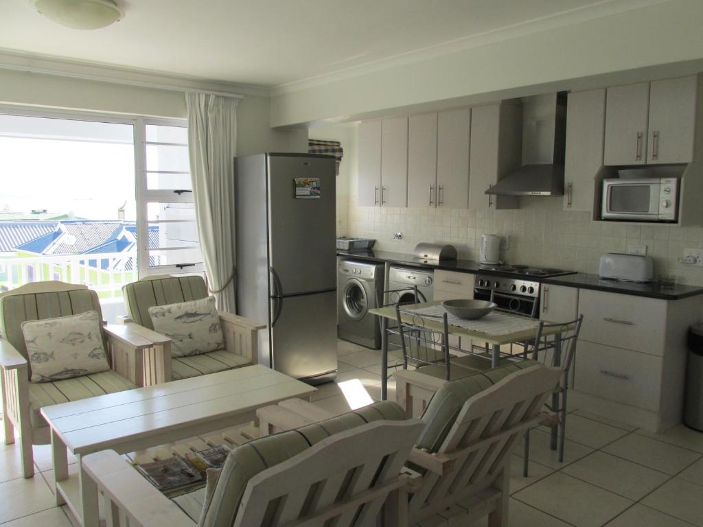 a kitchen with a table and chairs and a refrigerator at Point Village Accommodation - Alista in Mossel Bay