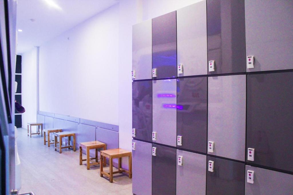una stanza con file di tavoli e sedie e una parete di Hotel Shakti Capsule a Bandung