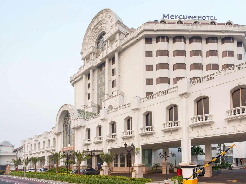 a large white building with a sign on it at Mercure Jakarta Batavia in Jakarta