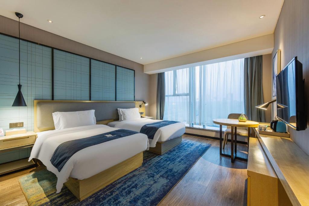 Postel nebo postele na pokoji v ubytování Echarm Hotel Wuhan Hanyang Wangjiawan Sixin Avenue Metro Station
