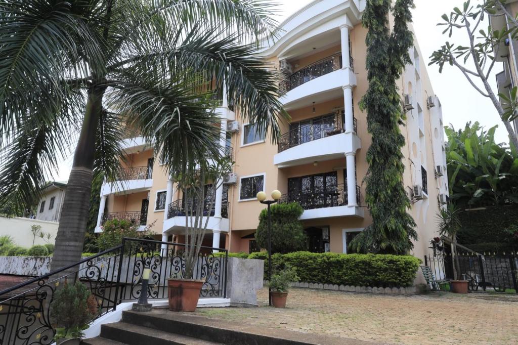 a building with palm trees in front of it at Residence La Marina in Yaoundé