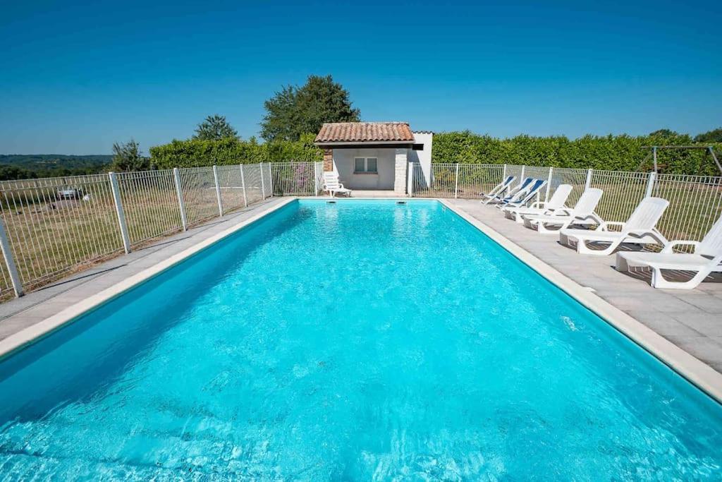 une piscine avec des chaises et une maison dans l'établissement Maison Périgourdine 14 personnes avec piscine, à Busserolles