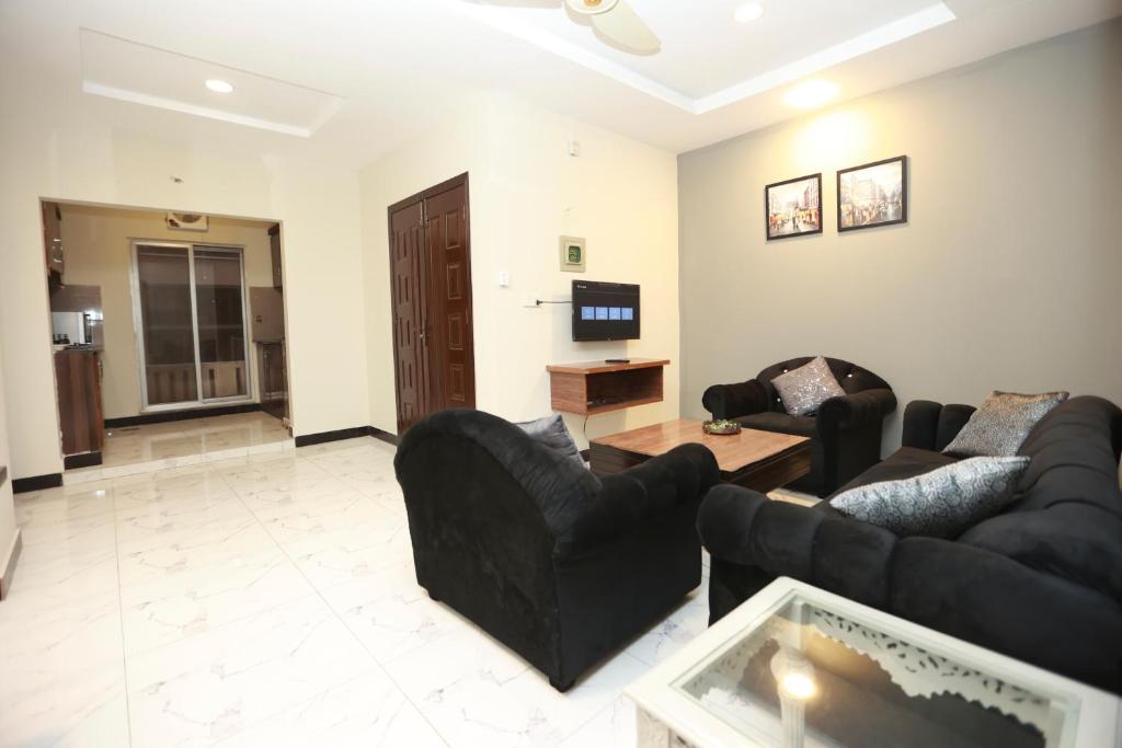un salon avec deux canapés et une télévision dans l'établissement Galaxy Hotel & Apartments, à Rawalpindi