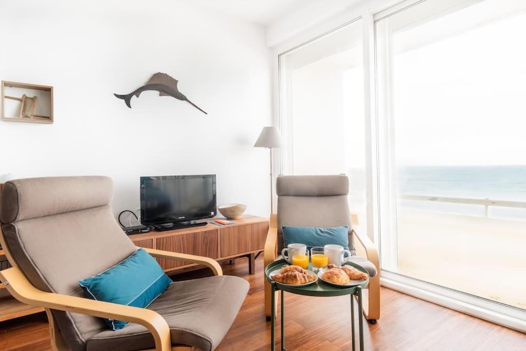 a living room with two chairs and a table with food on it at Le Rayon Vert - Vue sur l'aiguille et garage priv in Étretat