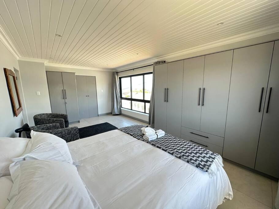 a bedroom with a large white bed and a window at DIE Huis House in Wilderness