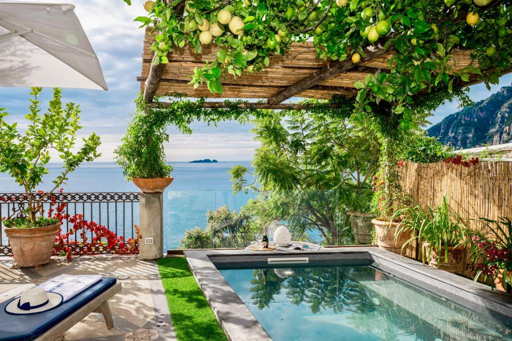 a swimming pool in a garden with a pergola at YourHome - Villa Aldo Marino in Positano
