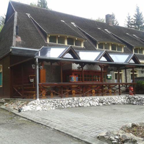 a large house with a large deck with at Odvaskő Panzió in Ugod