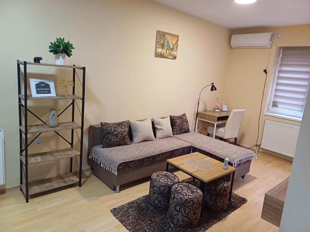 een woonkamer met een bank en een tafel bij NIKA apartman stan na dan in Šabac
