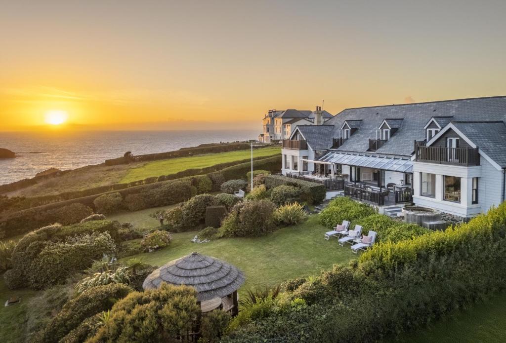 a house on a hill with the ocean in the background at Henscath House in Helston
