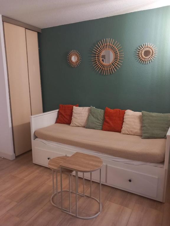 - un salon avec un canapé et deux miroirs dans l'établissement Studio climatisé, une place de parking à la Faviére, à Bormes-les-Mimosas